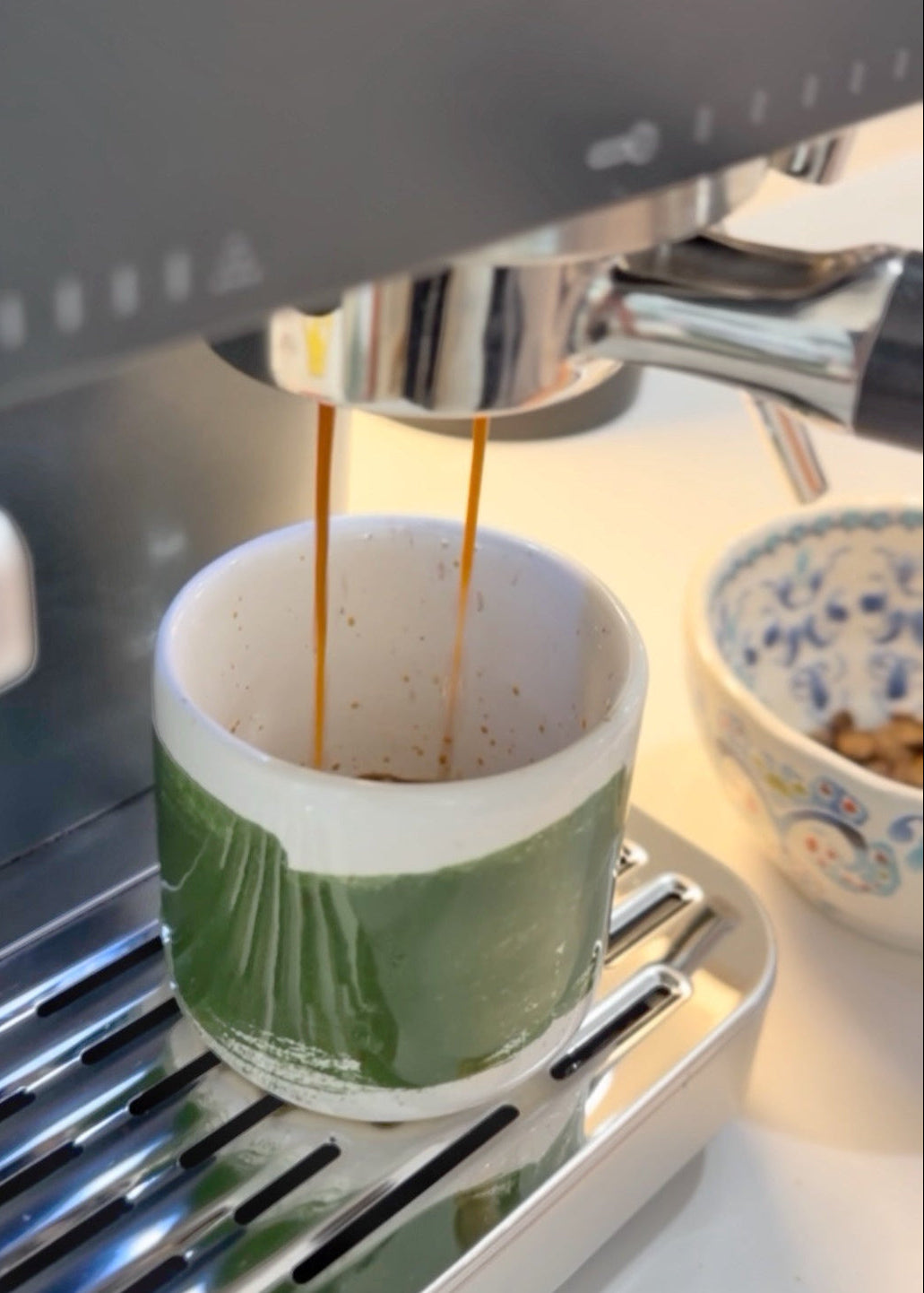 Espresso being poured into the candle vessel from a coffee machine.