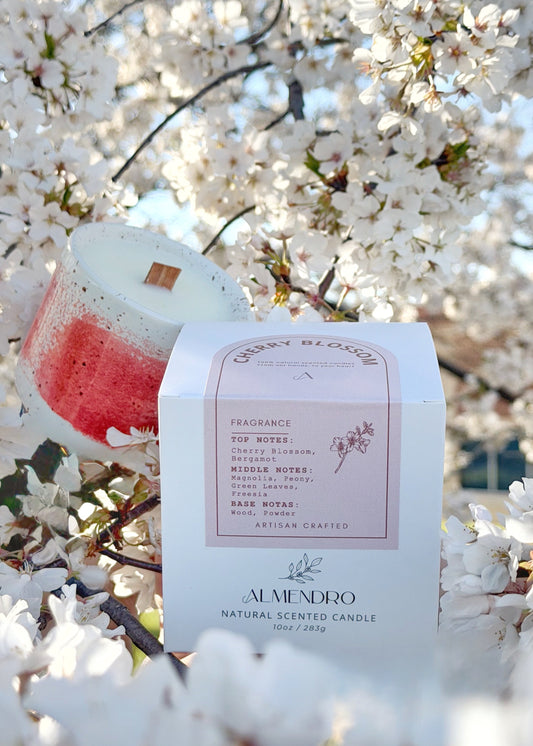 Candle with a cherry blossom design against a cherry blossom tree